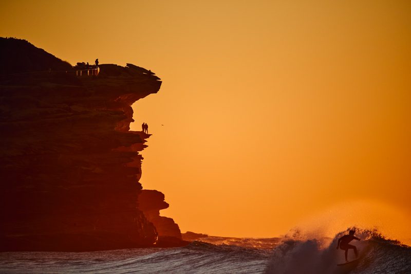 Men on a cliff and some dude going left